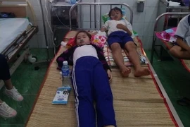 Các em học sinh đang điều trị tại Bệnh viện đa khoa huyện Trần Văn Thời. (Ảnh: Huỳnh Thế Anh/TTXVN)