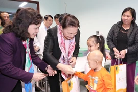 Chủ tịch Quốc hội Nguyễn Thị Kim Ngân tặng quà các bệnh nhân nhi đang điều trị tại bệnh viện. (Ảnh: Trọng Đức/TTXVN)