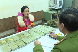 Đối tượng Thào Thị Dợ cùng tang vật tại Cơ quan Công an. (Ảnh: TTXVN phát)