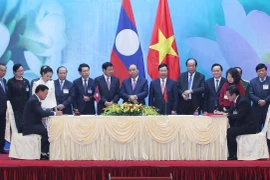 Thủ tướng Nguyễn Xuân Phúc và Thủ tướng Lào Thoongloun Sisoulith chứng kiến Lễ ký các văn bản hợp tác Việt Nam-Lào. (Ảnh: Lâm Khánh/TTXVN)