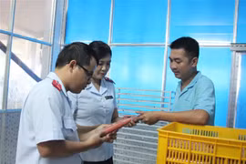 Lực lượng chức năng kiểm tra tại cơ sở sản xuất lạp xưởng. (Ảnh: Lê Thúy Hằng/TTXVN)