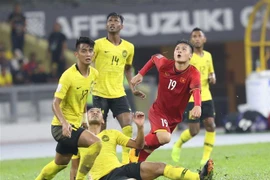 Quang Hải trong vòng vây hậu vệ Malaysia. (Ảnh: Hoàng Linh/TTXVN)