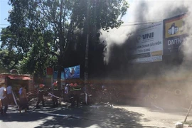 Lực lượng chức năng nhanh chóng có mặt tại hiện trường để dập tắt đám cháy. (Ảnh: Nam Thái/TTXVN)