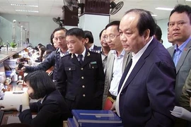 Bộ trưởng, Chủ nhiệm văn phòng chính phủ Mai Tiến Dũng kiểm tra qua trình làm thủ tục hải quan. (Ảnh: Trần Hoàng Ngọc/TTXVN)