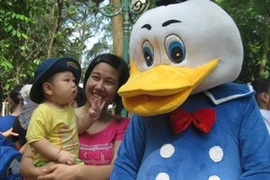Mẹ và bé hồn nhiên bên chú vịt ngộ nghĩnh. (Ảnh: Hùng Võ/Vietnam+)