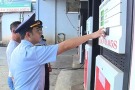 Cán bộ Cục Quản lý thị trường kiểm tra việc bán xăng dầu tại các cửa hàng bán lẻ xăng dầu. Ảnh minh họa. (Ảnh: TTXVN phát)