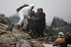 Lực lượng cứu hộ chuyển nạn nhân bị thương ra khỏi đống đổ nát sau trận động đất tại Afrin, tỉnh Aleppo (Syria). (Ảnh: AFP/TTXVN)