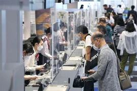 Hành khách làm thủ tục tại sân bay Haneda ở Tokyo, Nhật Bản. (Ảnh: Kyodo/TTXVN)