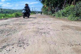 Mặt đường ĐH10 bong tróc, gồ ghề gây khó khăn cho người và phương tiện tham gia giao thông. (Ảnh: Đinh Hương/TTXVN)