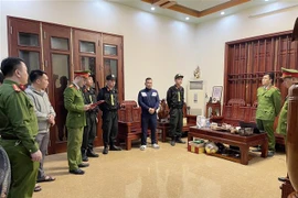 Khám xét và bắt đối tượng Trần Đức Dương, sinh năm 1970, chức vụ Giám đốc Công ty cổ phần đăng kiểm Bắc Kạn- 9701D. (Ảnh TTXVN phát)