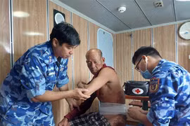 Cán bộ trên Tàu CSB 4035 băng bó, cấp cứu cho nạn nhân. (Ảnh: TTXVN phát)