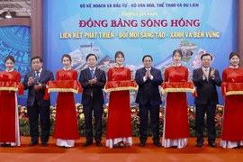 Thủ tướng Phạm Minh Chính và các đại biểu cắt băng khai mạc triển lãm ảnh Đồng bằng sông Hồng “Liên kết phát triển-Đổi mới sáng tạo-Xanh bền vững.” (Ảnh: Dương Giang/TTXVN)