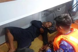 Cán bộ quân y trên Tàu CSB 2002, Bộ Tư lệnh Vùng Cảnh sát biển 4 động viên, chăm sóc y tế cho ngư dân gặp nạn. (Ảnh: TTXVN phát)