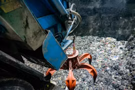 Chiếc cẩu siêu trọng được điều khiển từ xa sẽ đảo trộn và gắp rác từ bể chứa khổng lồ đưa vào lò đốt của Nhà máy điện rác Sóc Sơn. (Ảnh: Trung Nguyên/TTXVN)