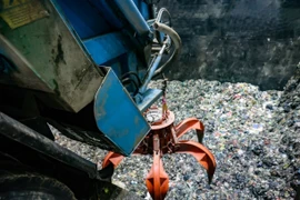 Chiếc cẩu siêu trọng được điều khiển từ xa sẽ đảo trộn và gắp rác từ bể chứa khổng lồ đưa vào lò đốt của Nhà máy điện rác Sóc Sơn. (Ảnh: Trung Nguyên/TTXVN)
