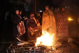 Người dân đốt lửa sưởi ấm sau khi bị mất nhà cửa do động đất tại Kahramanmaras, Thổ Nhĩ Kỳ. (Ảnh: AFP/TTXVN)