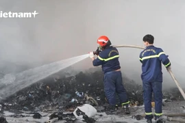 Lực lượng cứu hỏa đag dập tắt đám cháy. (Ảnh: P.V/Vietnam+)