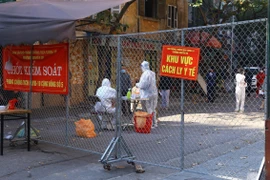 Lực lượng y tế phường Nguyễn Du lấy mẫu xét nghiệm cho người dân phố Đỗ Hành. (Ảnh: Hoàng Hiếu/TTXVN)