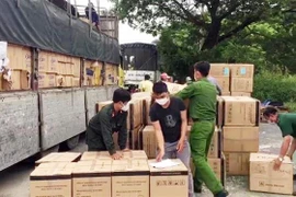 Lực lượng liên ngành kiểm đếm hàng hóa bị tạm giữ. (Ảnh: TTXVN phát)