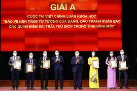 Ông Võ Văn Thưởng, Ủy viên Bộ Chính trị, Thường trực Ban Bí thư và ông Nguyễn Xuân Thắng, Ủy viên Bộ Chính trị, Giám đốc Học viện Chính trị quốc gia Hồ Chí Minh, Chủ tịch Hội đồng Lý luận Trung ương trao giải A cho các tác giả. (Ảnh: Minh Đức/TTXVN)