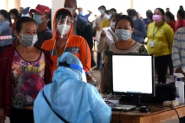 Công nhân khai báo y tế trong ngày đầu tiên trở lại công ty làm việc. (Ảnh: Công Phong/TTXVN)