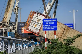 e container đâm vào dải phân cách bên phải đường và lao xuống taluy âm của đường dẫn lên cầu Thanh Trì. (Ảnh: Thành Đạt/TTXVN)