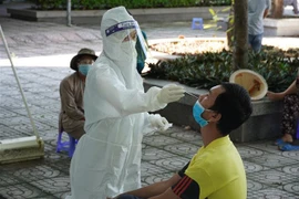 Nhân viên y tế lấy mẫu test nhanh cho người dân xã Long Sơn, thành phố Vũng Tàu - vùng đỏ của tỉnh. (Ảnh: Hoàng Nhị/TTXVN)