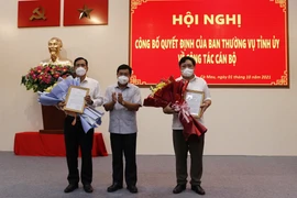 Ông Nguyễn Tiến Hải - Bí thư Tỉnh ủy, Chủ tịch Hội đồng Nhân dân tỉnh Cà Mau trao quyết định của Ban Thường vụ Tỉnh ủy về việc điều động công tác đối với ông Phạm Thành Ngại (bên phải) và ông Trần Hồng Quân tại hội nghị. (Ảnh: Kim Há/TTXVN)