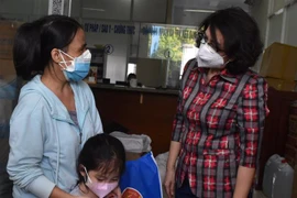 Chủ tịch Ủy ban Mặt trận Tổ quốc Thành phố Hồ Chí Minh Tô Thị Bích Châu thăm hỏi và tặng quà cho các em mồ côi vì COVID-19 tại quận 4. (Ảnh: Thu Hương/TTXVN)