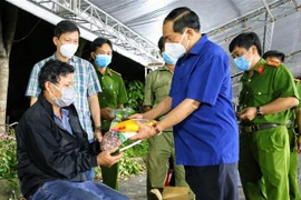 Thiếu tướng Nguyễn Văn Thuận, Giám đốc Công an thành phố Cần Thơ tặng quà hỗ trợ cho người dân về quê tại chốt kiểm soát ở quận Cái Răng tối 9/10. (Ảnh: Thanh Liêm/TTXVN)