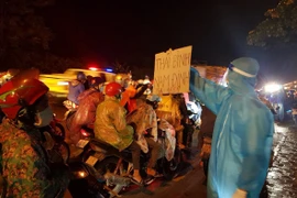 Lực lượng chức năng tỉnh Ninh Bình hỗ trợ công dân đi qua địa bàn. (Ảnh: Đức Phương/TTXVN)