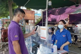  Người dân khai báo y tế bằng mã QR tại chốt kiểm soát dịch COVID-19 số 1 cầu Xuân Phương thành phố Phúc Yên. (Ảnh: Hoàng Hùng/TTXVN)