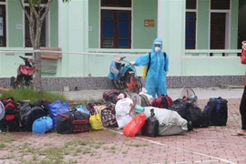 Phun khử khuẩn đồ đạc tư trang của các công dân từ miền Nam trở về sau khi hoàn thành cách ly 14 ngày tại Trung tâm huyện Tương Dương. (Ảnh: Bích Huệ/TTXVN)