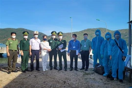 Lực lượng chức năng bàn giao 3 thuyền viên quốc tịch Trung Quốc gặp nạn trên biển cho Công ty Tree Marine. (Ảnh: Nguyên Linh/TTXVN)