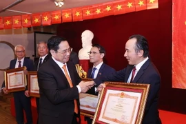 Thủ tướng Phạm Minh Chính tặng Bằng khen cho các kiều bào có thành tích trong công tác phòng, chống dịch. (Ảnh: Dương Giang/TTXVN)