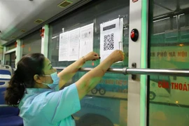 Dán mã QR tại bến xe để hành khách thực hiện khai báo y tế. (Ảnh: Hoàng Hiếu/TTXVN)