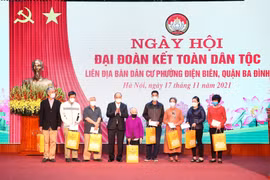 Chủ tịch nước Nguyễn Xuân Phúc trao tặng quà cho 8 hộ gia đình có hoàn cảnh khó khăn tại phường Điện Biên, quận Ba Đình. (Ảnh: Phạm Kiên/TTXVN)