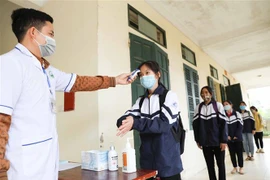Đo thân nhiệt, sát khuẩn tay cho học sinh. (Ảnh minh họa. Nguồn: TTXVN)