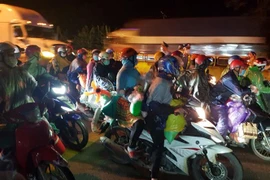 Lực lượng chức năng tỉnh Ninh Bình hỗ trợ công dân đi xe môtô qua địa bàn. (Ảnh: Đức Phương/TTXVN)
