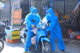 Các tình nguyện viên, thah niên xung kích chở đồ nhu yếu phẩm vào cho người dân trong khu cách ly. (Ảnh: Tuấn Anh/TTXVN)