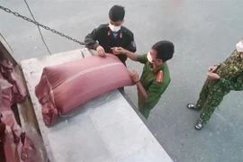 Lực lượng chức năng kiểm tra số lượng hàng hóa được vận chuyển trên xe các tải. (Ảnh: TTXVN phát)