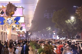 Người và phương tiện trên tuyến phố Hàng Bài hướng về khu vực Hồ Gươm trong đêm Noel. (Ảnh: Hoàng Hiếu/TTXVN)