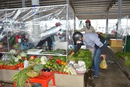 Người dân mua hàng tại chợ truyền thống. (Nguồn: TTXVN)