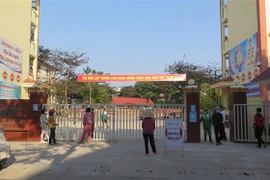 Phụ huynh Trường THCS Kim Tân, thành phố Lào Cai ở ngoài cổng trường đợi con em mình lấy mẫu xét nghiệm COVID-19. (Ảnh: TTXVN phát)