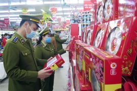 Lực lượng quản lý thị trường kiểm tra hàng hóa. (Ảnh: Trần Trang/TTXVN)