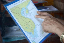  Các ngư dân tìm hiểu kỹ sơ đồ vùng biển Việt Nam để không vi phạm lãnh hải nước khác trong quá trình khai thác thủy sản. (Ảnh: Quốc Dũng/TTXVN)