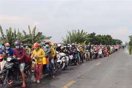 Rất đông người dân từ các vùng dịch trở về các tỉnh miền Tây, trong đó có Đồng Tháp bằng phương tiện xe máy. (Ảnh: Chương Đài/TTXVN)