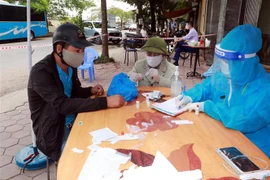 Người dân phải khai báo y tế, test nhanh COVID-19 khi đến khu vực ngõ 587, đường Trần Nhân Tông, phường Vị Hoàng, thành phố Nam Định. (Ảnh: Nguyễn Lành/TTXVN)