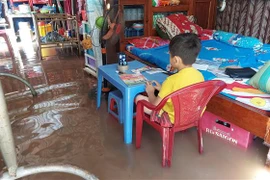 Triều cường gây ngập nhà, ảnh hưởng đến sinh hoạt của người dân. (Ảnh: Huỳnh Phúc Hậu/TTXVN)