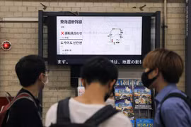 Người dân theo dõi thông tin về lịch trình các chuyến tàu bị hoãn ở nhà ga Tokyo, Nhật Bản do ảnh hưởng của động đất, ngày 7/10/2021. (Ảnh: THX/TTXVN)